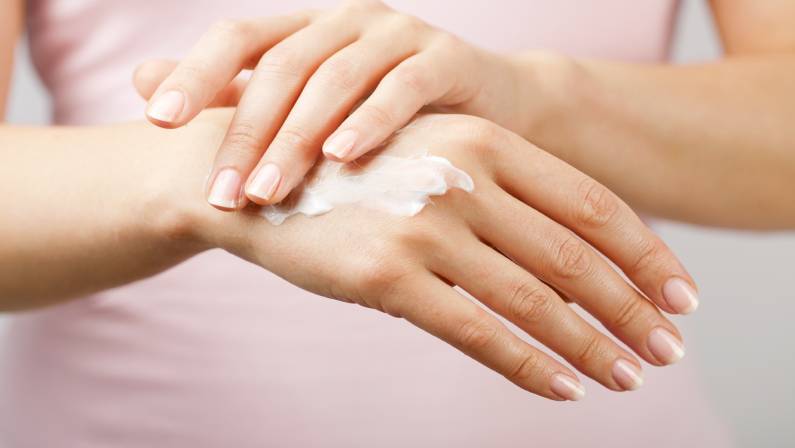 Woman applying moisturizer in her hands
