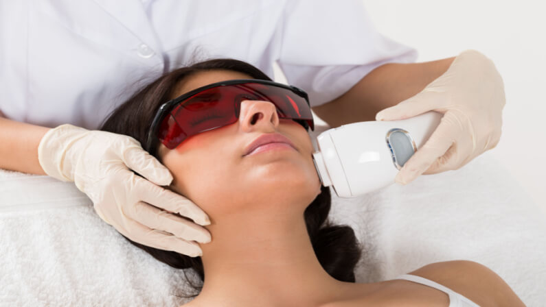 Woman receiving laser therapy on her face